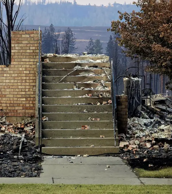 Concrete front steps and a brick pier. The house they led into is the ash and brick on both sides.