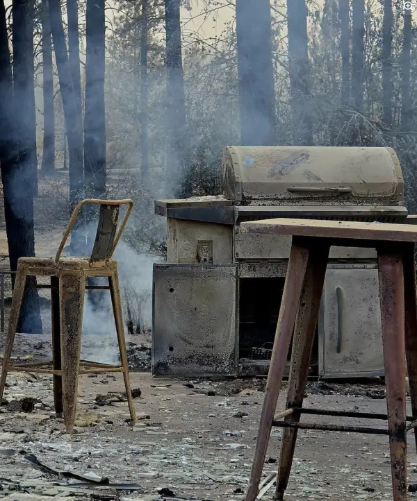 Bar stools and a built-in grill left standing. Smoke was still drifting through the trees behind them.
